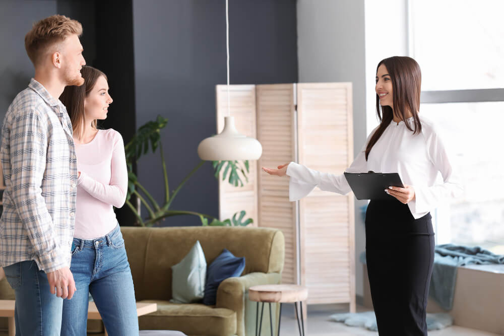 real estate agent showing young couple new house 1