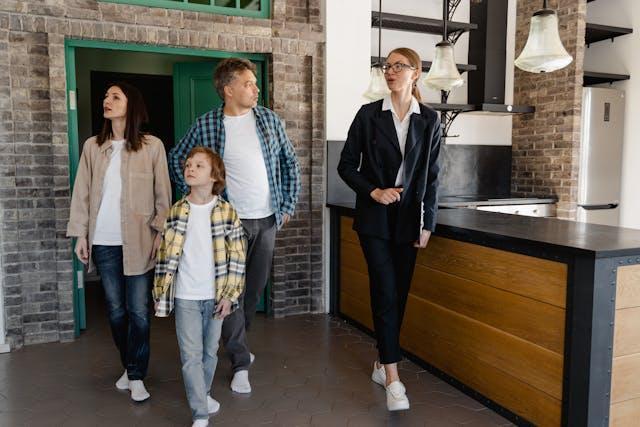  Real estate agent showing a home to a family, walking through a modern kitchen area