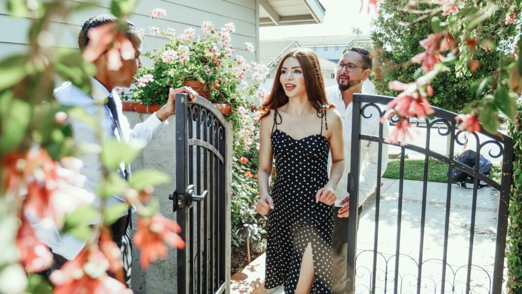 Man greeting a couple at the gate